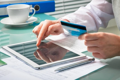 man using tablet with a credit card