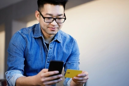 man holding credit card and phone