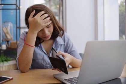 unhappy woman with no money in purse