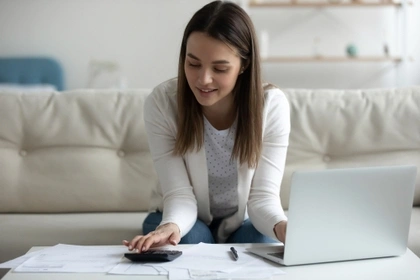 woman using calculator and laptop