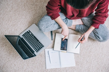Overhead view of young brunette woman using laptop
