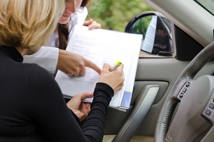 Woman sat in the car signing a document