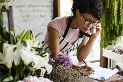 woman talking to customer on phone in florist