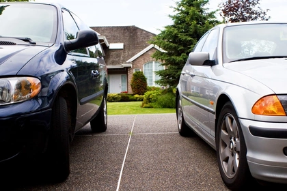 two cars parked outside of a house