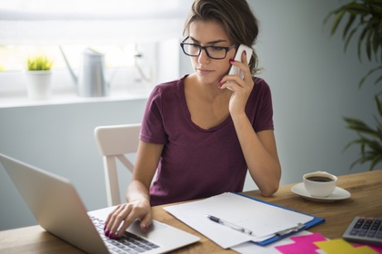 woman on phone sat at desk