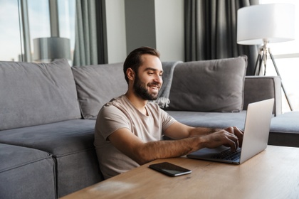 smiling man on laptop in his lounge