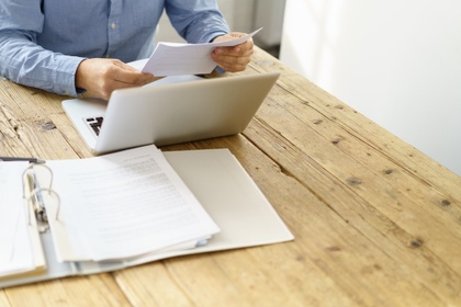 man at desk looking at paperwork