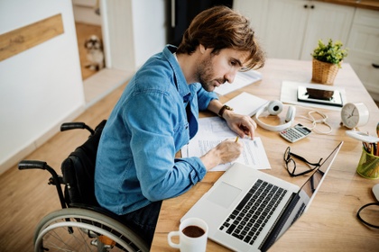 man in wheelchair filing in paperwork