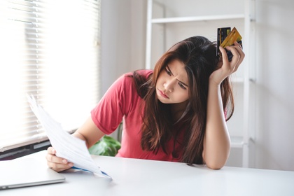 worried woman holding credit cards