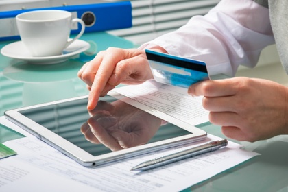 Man entering card details into tablet.