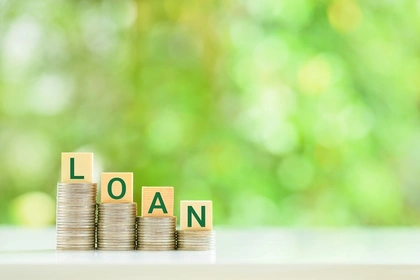 The word loan written in cubes on stacks of coins