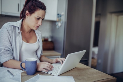 woman on laptop drinking tea