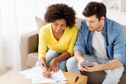 Couple on a sofa looking at paperwork 