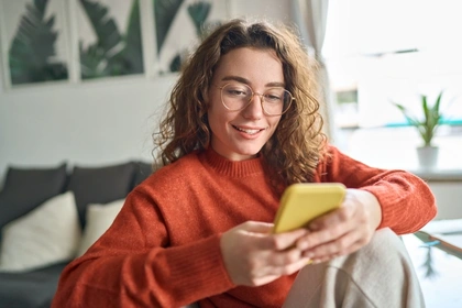 Person holding a credit card while browsing on a laptop
