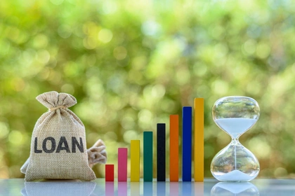 Bag with loan written on it beside an egg timer