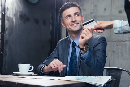 Business man handing over his credit card to make a payment