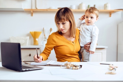 working mum at desk holding toddler