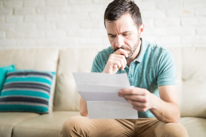 stressed man looking at bank statements
