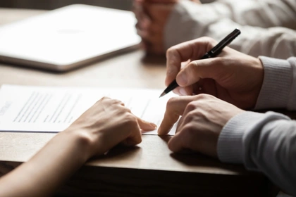 People signing an agreement