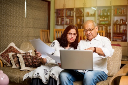 couple looking at laptop  in living room