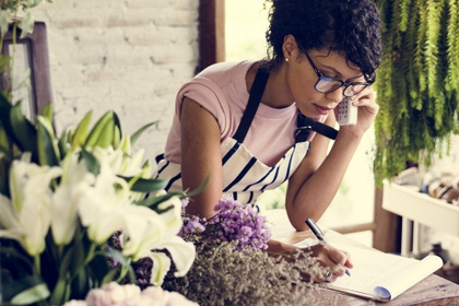 woman talking to customer on phone in florist