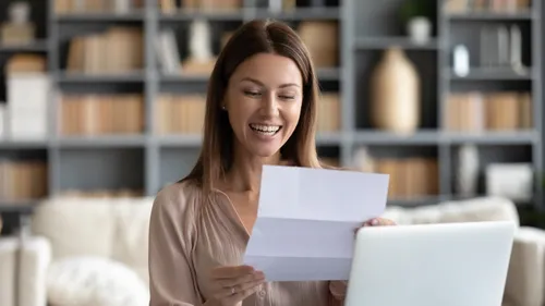 Woman reading loan documents and smiling
