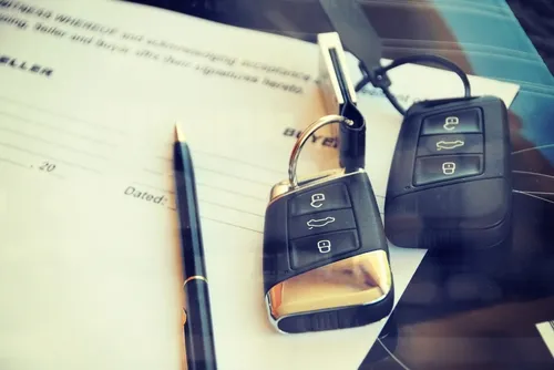 Two sets of car keys and a contract