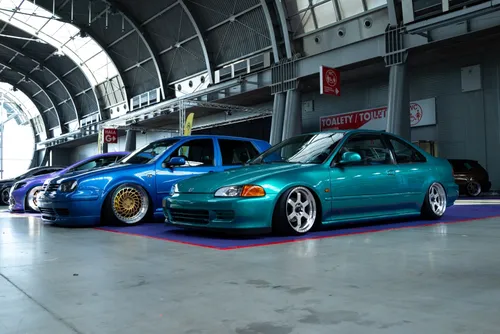 Modified cars parked up in a garage