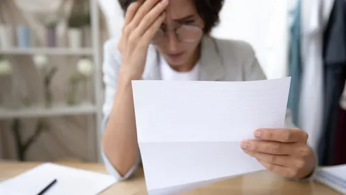 Woman looking at a bill with concern