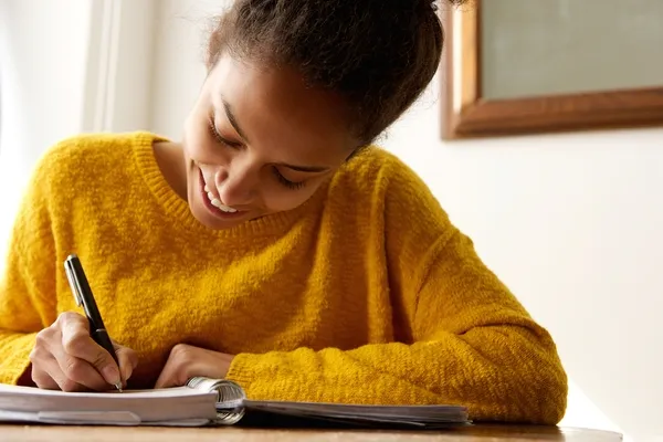 happy woman writing in notepad