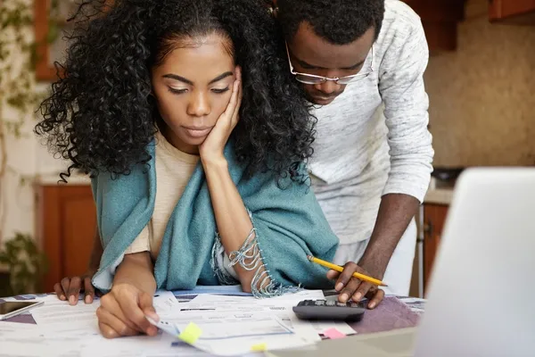 worried couple looking at bills