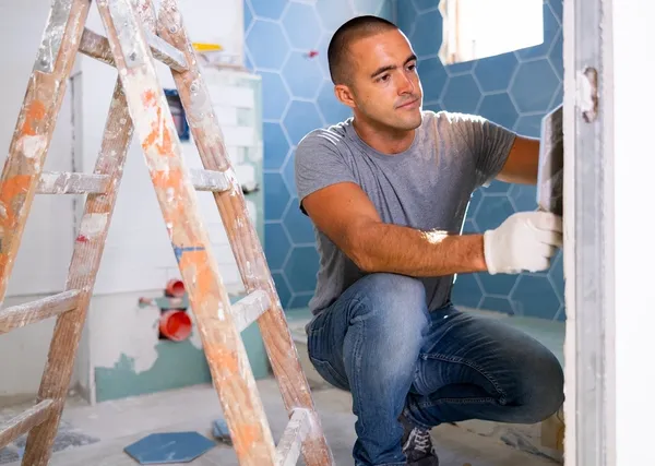 man tiling a bathroom
