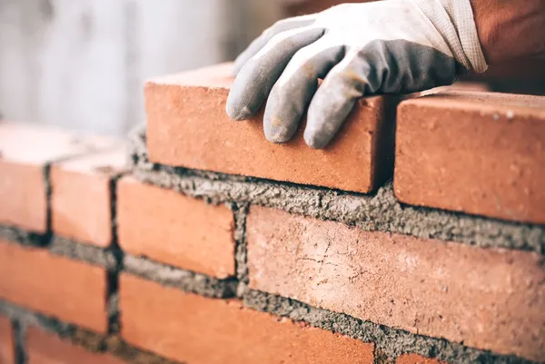 Close up of a bricklayer layering bricks on a construction site