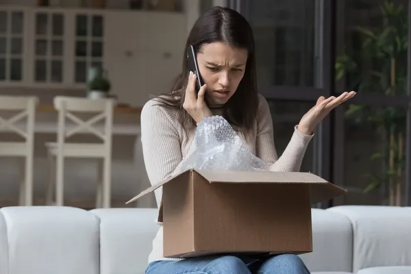 woman on the phone with a damaged parcel