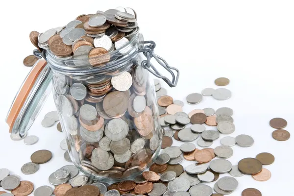 Mason jar with a variety of British coins on a white background