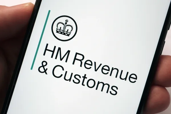 Hand holding a mobile phone with HM Revenue & Customs on the screen