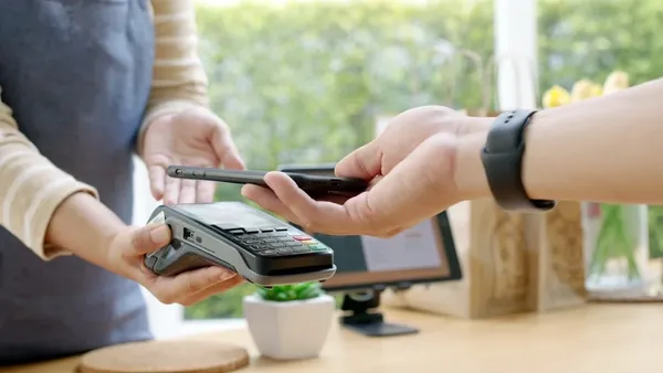 person using their phone to pay on a card terminal