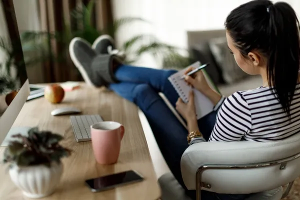 Woman at desk creating a list of her bills