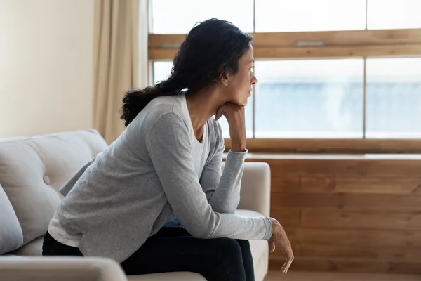 Woman sat by window thinking