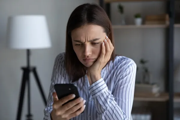Woman looking at her smartphone, worried
