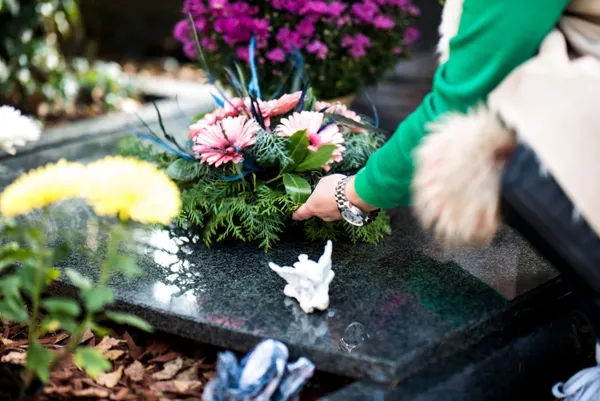 Someone laying flowers at a funeral