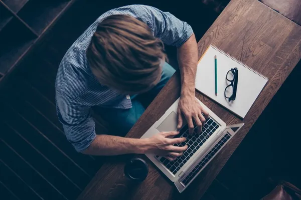 Birds eye view of a man sat at his laptop.