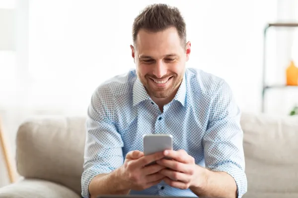 young man smiling while using mobile phone