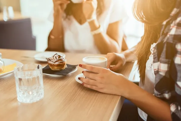 Friends drinking coffee and eating together