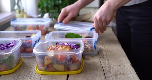 Man placing food prep into tupperware boxes