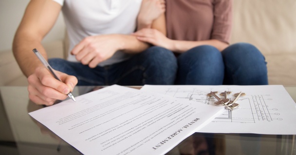 Couple signing tenancy agreement