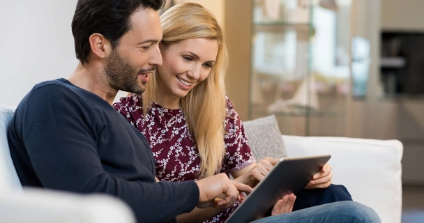 happy couple looking at laptop