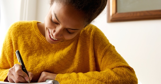 happy woman writing in notepad