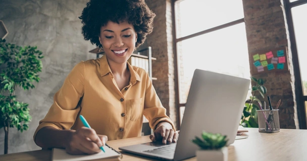 woman on laptop with notepad