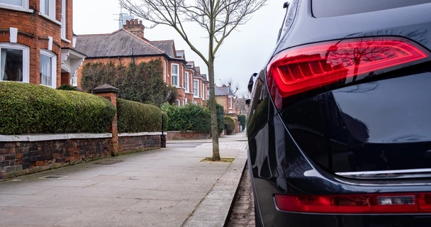 Black car parked up on residential street